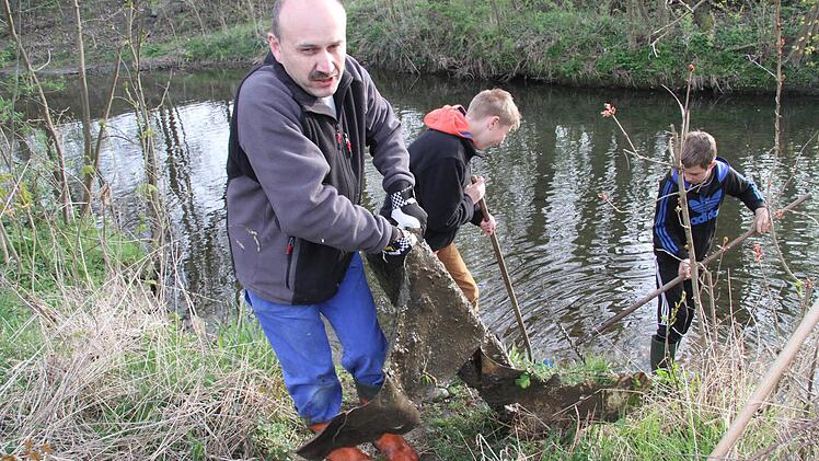 Mit vereinten Kräften schafften es die Helfer dann, den PVC-Boden aus dem Bach zu befördern.