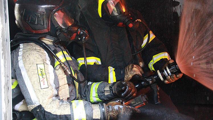 1200 Grad herrschen über ihren Köpfen. Mit einer speziellen Löschtechnik sollen die Feuerwehrmänner Wärme und Rauchgas wegdrücken. Foto: Carmen Schmitt