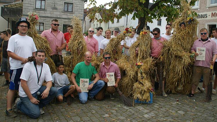 Zur Ehrung von drei "Ehemaligen" versammelten sich alle Strohbären und ihre Wächter an der Linde.
