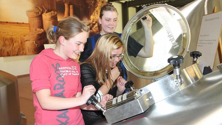 Der Beruf des Brauers ist nicht nur was für Jungs: Die angehende Brauerin und Mälzerin Teresa Klotz gibt im Sudhaus der Kulmbacher Brauerei einen Einblick in den Maischbottich und in ihren Beruf. Vanessa Barthelmann (links) und Clara Thümling hat der Girls Day in der Brauerei gefallen. Fotos: Sebastian Martin