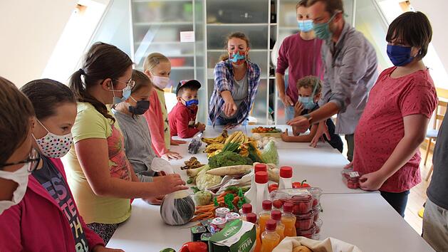 Nicole Fläschner (Mitte) bespricht mit den Kindern, was sich alles aus den Lebensmitteln machen lässt. Foto: Julia Raab