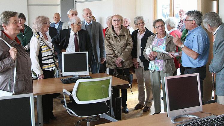 Die Arbeit mit Computern ist ein wichtiger Teil der Ausbildung am Bestatterzentrum. Die Bestatter müssen zum Beispiel Todesanzeigen gestalten können, erfuhren die Teilnehmer am Vierziger-Treffen. Norbert Mauer (2. von rechts) erklärte die Einrichtung. Fotos: Dieter Britz