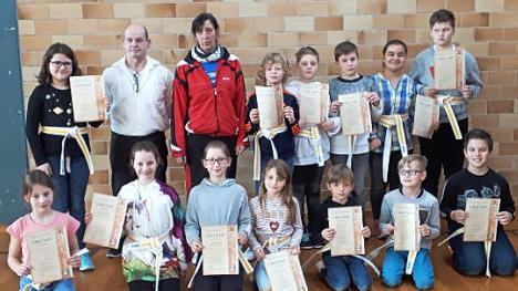 Sie sind stolz auf ihre weiß-gelben Gürtel und ihre Urkunden zur gemeisterten Selbstverteidigungsprüfung. Mit im Bild die Ausbilder Alfred Busse und Heike Bittner (hintere Reihe Zweiter und Dritte von links)  Fotos: K. H. Hofmann