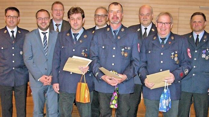 Vertreter der Feuerwehr und Ehrengäste flankieren die für 40 aktive Dienstjahre ausgezeichneten Joachim Nowak, Jürgen Jacob und Herbert Höhn (Bildmitte, von links). Foto: Klaus Oelzner