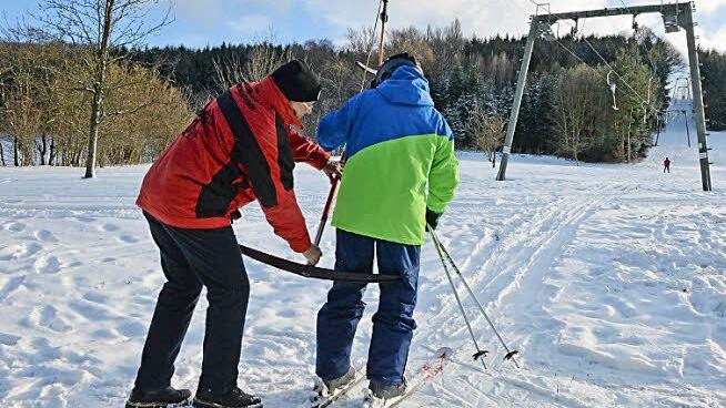 Norbert Uhl, ebenfalls Gründungsmitglied des Skiclubs, hilft den Skifahrern bei der Saisoneröffnung am Dienstag in den Schlepplift. Und schon geht es den Berg hinauf.