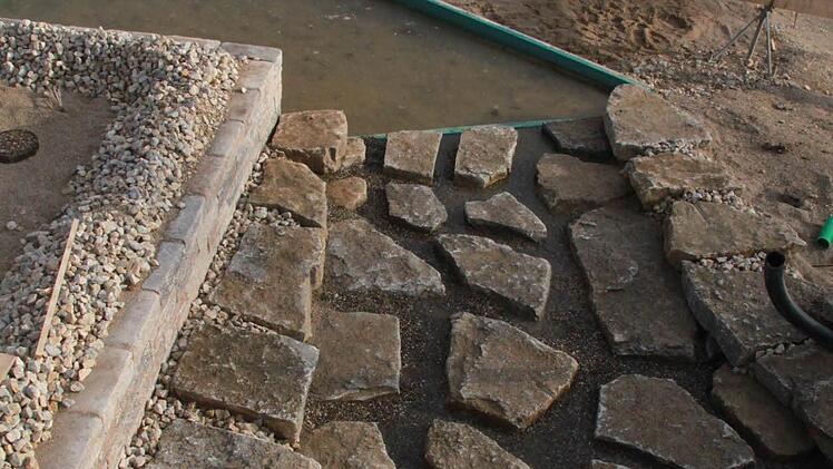 Das Umfeld des Badesees wird mit naturnahem Material gestaltet.