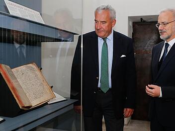 Werner Taegert (rechts) und Minister Ludwig Spaenle vor der Vitrine, in der das Lorscher Arzneibuch ausgestellt ist. Fotos: Matthias Hoch
