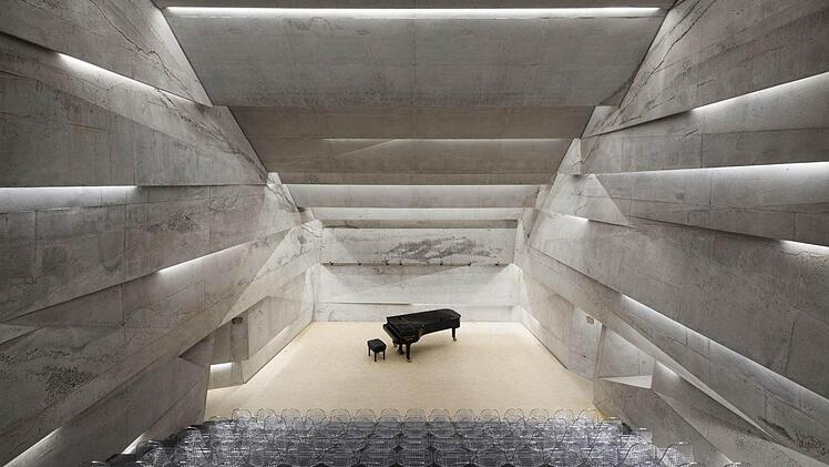 Blick aufs Konzertpodium. Der Saal folgt der Hangneigung, die Gestaltung der Wände orientiert sich rein an der Akustik.