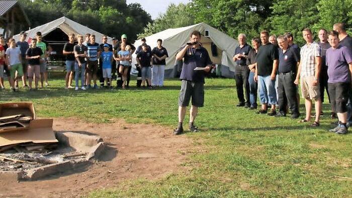 Henry Reisenweber (Mitte) vom Kreisjugendverband der Feuerwehr freute sich in seiner Begrüßung über den guten Besuch beim diesjährigen Zeltlager in Autenhausen. Foto: Bettina Knauth