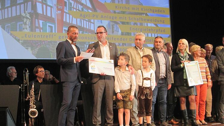 Moderator Jürgen Gläser (l.) gratulierte und interviewte Bürgermeister René Gerner zur Silberauszeichnung bei Wettbewerb "Unser Dorf hat Zukunft". Der Nachwuchs, Tom Gerner Und Emilian Luxem sowie Alt-Bürgermeister Peter Hart nahmen den Preis stol...