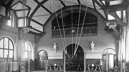 Eine historische Ansicht der Turnhalle. Rechts hinten: Baumeister Max Böhme. Die Decke war damals noch bemalt. Foto: Stadt Coburg
