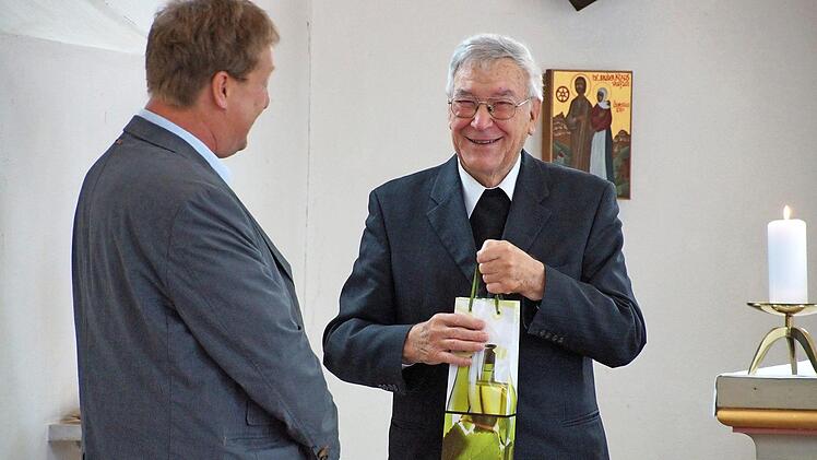 Harald Geis (links) übergab ein Geschenk an Pfarrer Albin Lieblein zu dessen 85. Geburtstag. Foto: Anton Then