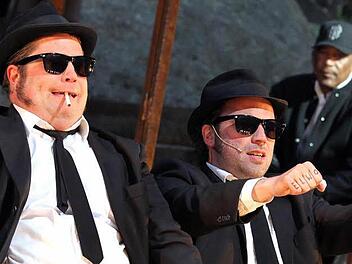 Verfolgungsjagd ohne Auto? Bei den "Blues Brothers" auf der Luisenburg cruisen und rasen Jake (Andreas Birkner, links) und Elwood (Michael Kamp) dank der Hilfe des menschlichen Tonstudios Ron Williams (hinten) über imaginäre Straßen. Foto: Bessermann