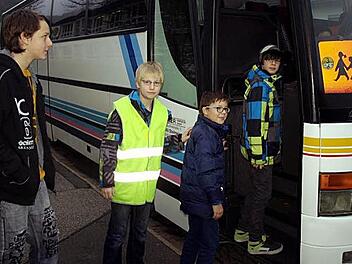 Adrian Schön (mit Weste) demonstriert mit seinen Buslotsenkollegen Maurice Wilhelm, Jan Föhrweiser und Bastian Kräußling (von links) wie das geordnete Einsteigen in den Bus erfolgen sollte. Foto: Susanne Deuerling
