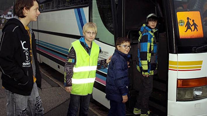 Adrian Schön (mit Weste) demonstriert mit seinen Buslotsenkollegen Maurice Wilhelm, Jan Föhrweiser und Bastian Kräußling (von links) wie das geordnete Einsteigen in den Bus erfolgen sollte. Foto: Susanne Deuerling