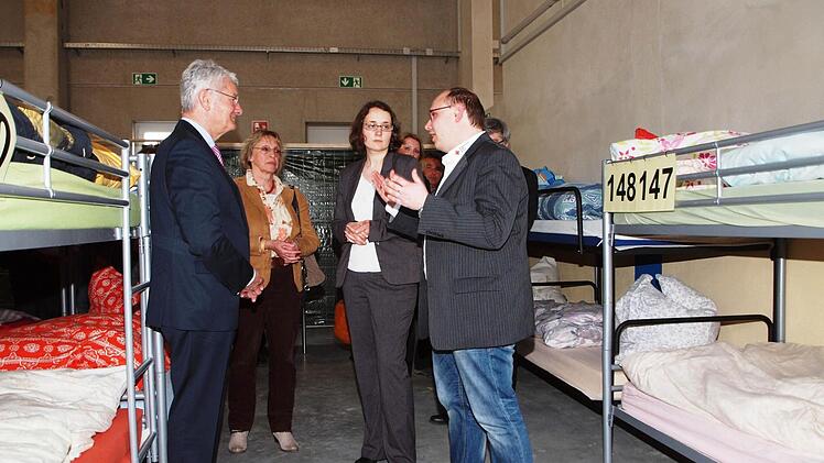 BRK-Leiter soziale Dienste Frank Gerstner, Abteilungsleiterin Anja Meins vom Landratsamt und der BRK-Präsident Theo Zellner (vorne von rechts) im Gespräch in der Notunterkunft. Foto: Alfred Thieret
