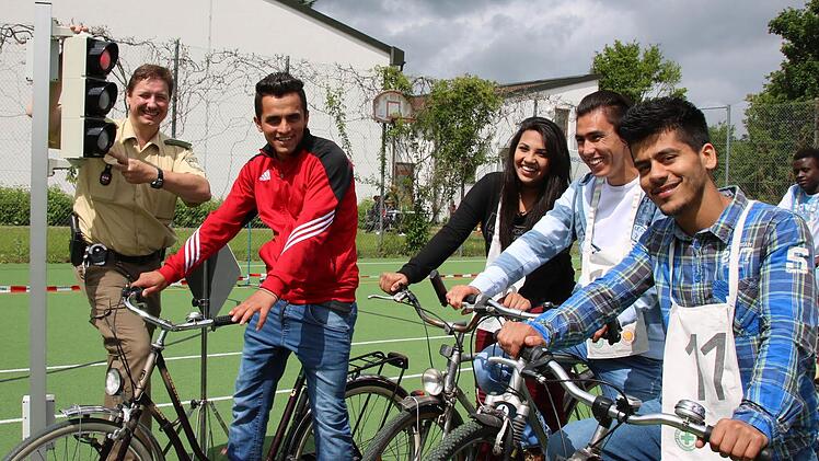 Prävention ist bei der Bad Kissinger Polizei unter anderem die Aufgabe von Verkehrserzieher Matthias Kleren (von links): Auf diesem Bild erläutert er den Flüchtlingen Shoaib Hamidi, Suzan Ahmad, Aman Mohammadi und Ahmad Schoaib Saqebi das richtige Verhalten an einer Kreuzung mit Ampel. Fotos: Ralf Ruppert