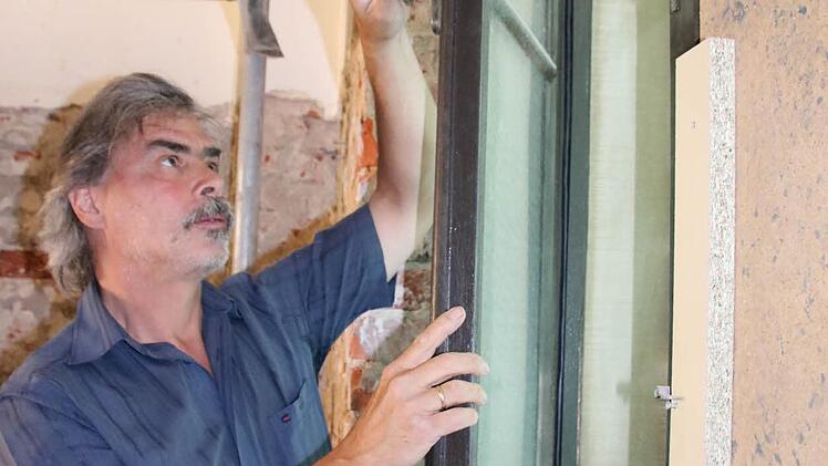 Architekt Christian Teichmann an einem der bereits renovierten Fenster. Foto: Ralf Ruppert