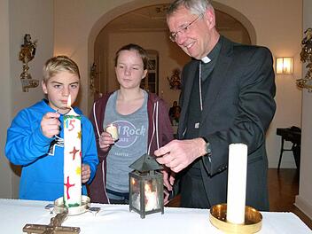 Die beiden Pfadfinder Theo und Martha entzündeten mit dem Friedenslicht aus Bethlehem die Osterkerze in der Hauskapelle von Erzbischof Ludwig Schick. Foto: Marion Krüger-Hundrup
