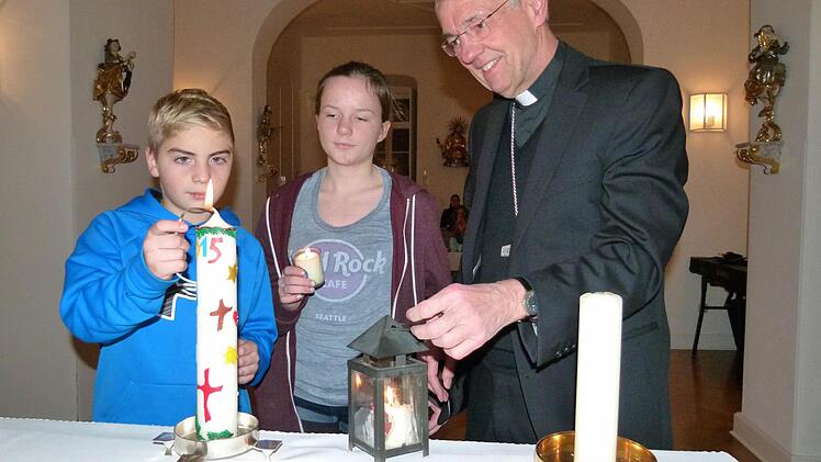 Die beiden Pfadfinder Theo und Martha entzündeten mit dem Friedenslicht aus Bethlehem die Osterkerze in der Hauskapelle von Erzbischof Ludwig Schick. Foto: Marion Krüger-Hundrup