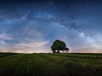 Sternenhimmel &uuml;ber Feld mit Kapelle und Baum in der Oberpfalz in Bayern.