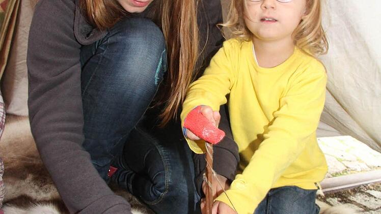 Ganz schön anstrengend, mit dem Handbohrer den Speckstein zu durchbohren, stellte Sophie Milz (3) fest, doch Mama Sarah hilft. Foto: Sonja Adam