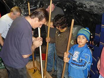 In Holzbottichen zerkleinern die Wallenfelser mit alten Spezialwerkzeugen Erdkohlrabi, wie in Wallenfels die Steckrüben genannt werden, Möhren, Lauch, Wirsing und Kraut. Gilbert Weiß, Markus Weiß (linke Seite), Bastian und Max Buckreus sowie Manfred Stöcker (rechte Seite von vorne nach hinten) sind mit Feuereifer bei der Sache. Fotos: Sonja Adam