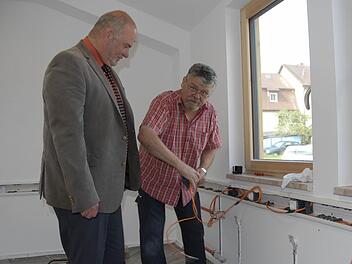 Bürgermeister Ralf Holzmann (links) ist stolz auf das ehrenamtliche Engagement der Rugendorfer beim Umbau der ehemaligen Raiffeisen-Lagerhalle zum Dorfladen. Harald Hohner ist überall zur Stelle, wo seine Fachkompetenz als Elektriker gefragt ist. Foto: Dagmar Besand