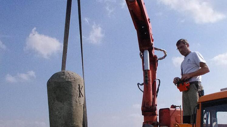 Steinrestaurator Wilhelm Keim manövriert den Zeitzeugen an seinen Standort, direkt an der Kreisstraße 22 zwischen Burkersdorf und Küps.