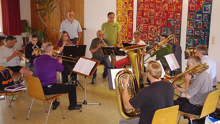 Der Posaunenchor Kronach probt unter Leitung von Dekanatskantor Marius Popp für das Benefizkonzert am Sonntag. Peter Witton und Frank Schuberth vom Hospizverein Kronach hören interessiert zu.  Foto: Heike Schülein