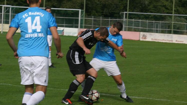Der Eberner Liebermann (dunkles Trikot) im Kampf um Ball gegen den Redwitzer Beier.