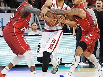 Die Würzburger Marshawn Powell (l.) und Maurice Stuckey (r.) greifen dem Bamberger Aufbauspieler Maodo Lo in den Arm. Foto: Daniel Löb