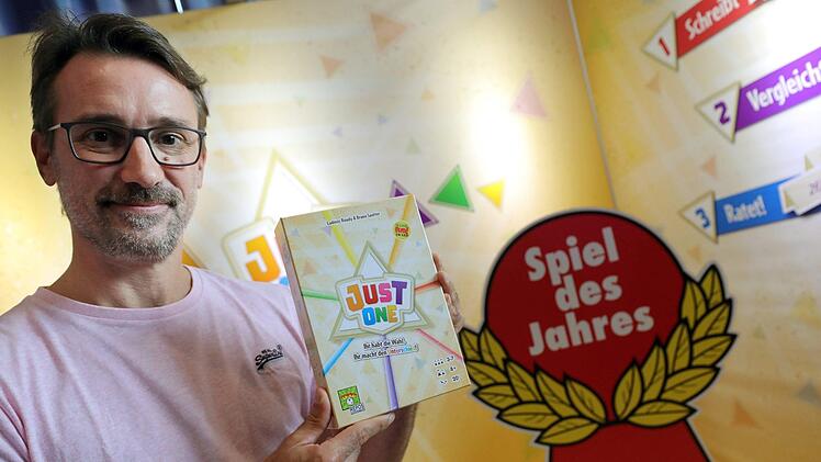 Bruno Sautter h&auml;lt sein Spiel &laquo;Just One&raquo; in den H&auml;nde, das zum &laquo;Spiel des Jahres 2019&raquo; gew&auml;hlt wurde. Das Wortrate-Spiel ist im Verlag Repos Peoduction erschienen. Foto: Wolfgang Kumm/dpa