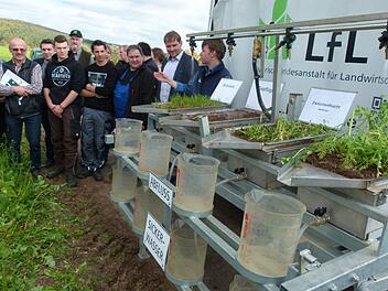 Michael Kistler (rechts) von der Bayerischen Landesanstalt für Landwirtschaft in Freising erläutert den zahlreichen Teilnehmern die Wirkungsweise eines  Regensimulators. Foto: Lothar Weidner
