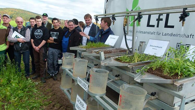 Michael Kistler (rechts) von der Bayerischen Landesanstalt für Landwirtschaft in Freising erläutert den zahlreichen Teilnehmern die Wirkungsweise eines  Regensimulators. Foto: Lothar Weidner