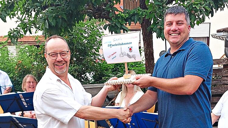 B&uuml;rgermeister Heinrich Starrach (rechts) &uuml;berreicht das SaaleMusicum-Flo&szlig; an den Vorsitzenden Martin Schmelz (links).