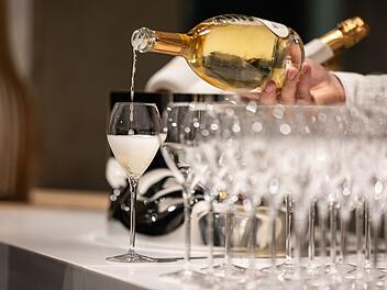 Kellner schenkt ein Glas Champagner ein