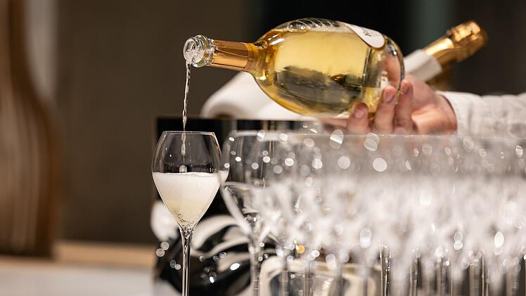 Kellner schenkt ein Glas Champagner ein