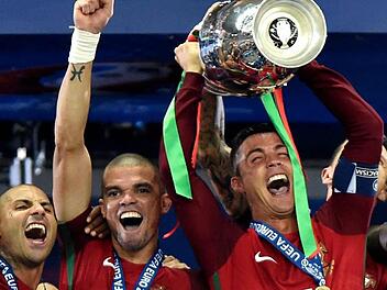 Cristiano Ronaldo (rechts) und seine Kumpels Ricardo Quaresma (links) und Pepe jubeln mit dem Pott - Portugal ist Europameister. Foto: Tibor Illyes/epa