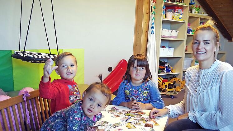 Ida, Michl und Anni Kolb (v. l.) spielen gemeinsam mit ihrer Mutter Katrin Kolb das Familien-Memory mit Motiven aus ihrer Kindertagesstätte St. Laurentius Neufang.  Fotos: Heike Schülein