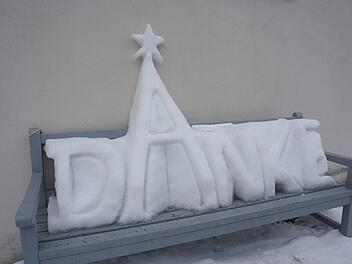 Seinem Dank hat ein unbekannter Künstler mit einem Schneekunstwerk an der Mauer der katholischen  Stadtpfarrkirche St. Georg in Bischofsheim Ausdruck verliehen. Foto: Marion Eckert