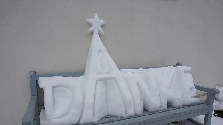 Seinem Dank hat ein unbekannter Künstler mit einem Schneekunstwerk an der Mauer der katholischen  Stadtpfarrkirche St. Georg in Bischofsheim Ausdruck verliehen. Foto: Marion Eckert