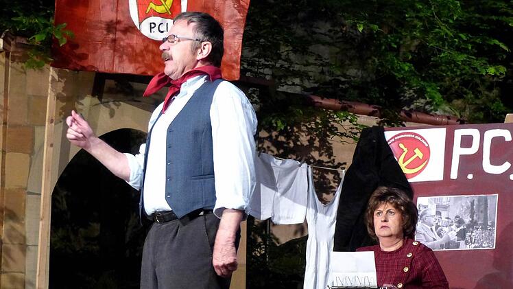 Bei seiner Arbeit wird der rote Bürgermeister Peppone (Siegfried Küspert) von seiner Frau Ariana (Marion Regnet) unterstützt.