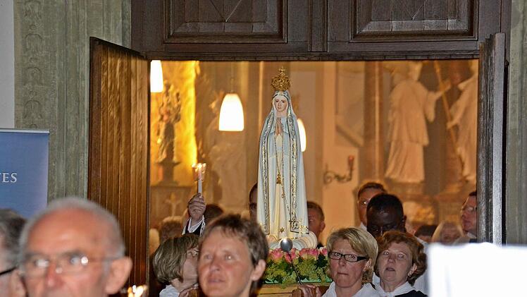 Frauen trugen das Bild der Gottesmutter, das mit vielen Blumen geschmückt war. Dahinter die Geistlichkeit. Foto: Friedrich