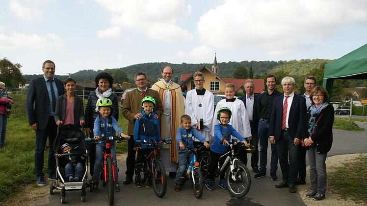 Groß war am Donnerstag die Freude über den neuen Radweg zwischen Fabrikschleichach und Karbach bei (hinten von links) Bürgermeister Matthias Bäuerlein, Gemeinderätin Monika Weinbeer, Staatssekretär Gerhard Eck,  Pfarrer Kurt Wolf und seinen Ministranten, Klaus und Michael Thomas (Straßenbau Thomas), Manfred Rott vom Staatlichen Bauamt, Kai Niedergesäß vom Planungsbüro Alka und Ortssprecherin Rosi Keller. Fabian, Valentin, Sven und Finn starteten dann gleich zur ersten Testfahrt.