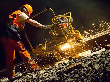 Marcel Gaulke schleift die frisch verschweißten Schienenstücke auf dem Abschnitt bei Breitengüßbach ab. Foto: Matthias Hoch