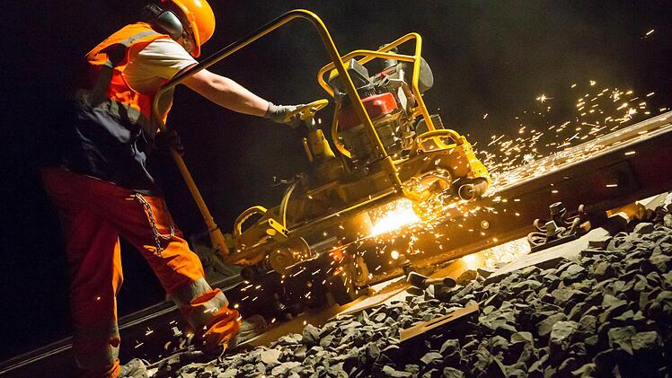 Marcel Gaulke schleift die frisch verschweißten Schienenstücke auf dem Abschnitt bei Breitengüßbach ab. Foto: Matthias Hoch