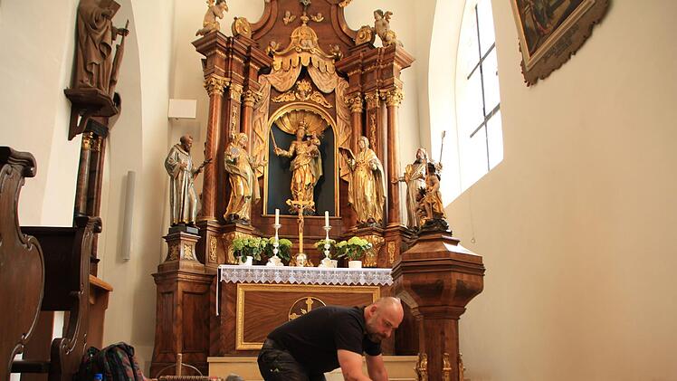 Handwerker haben das Betonfundament vor dem Seitenaltar gekürzt und mit neuen Fliesen verkleidet. Darauf kommen dann die Holzpodeste. Fotos: Franziska Rieger