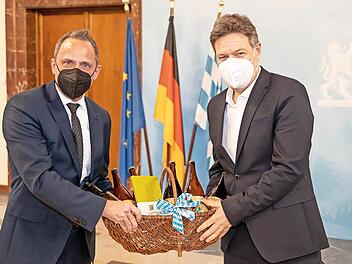 Thorsten Glauber (l.) überreicht Robert Habeck einen Geschenkkorb aus der Fränkischen Schweiz.