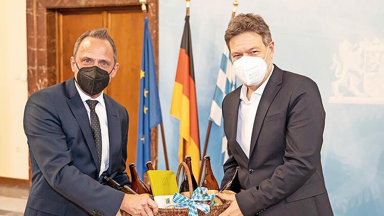 Thorsten Glauber (l.) überreicht Robert Habeck einen Geschenkkorb aus der Fränkischen Schweiz.